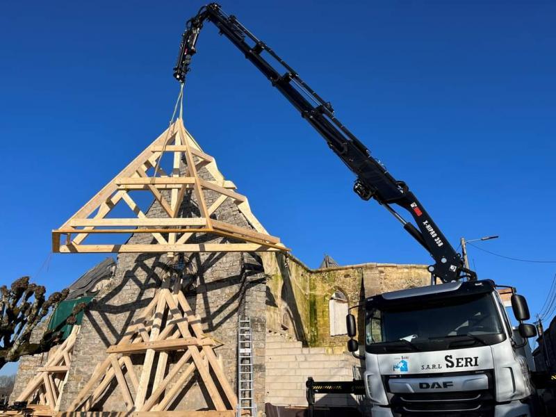 Grue montant une charpente en bois